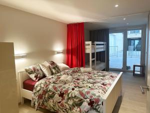 a bedroom with a bed and a red curtain at Art Donna met zeezicht in Middelkerke