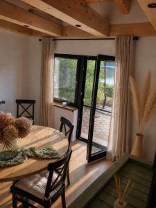 a dining room with a table and a large window at Das Seehaus Buckow in Buckow