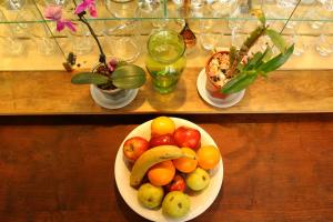 a bowl of fruit on a table with plates of food at As Nancy B&B in Ushuaia