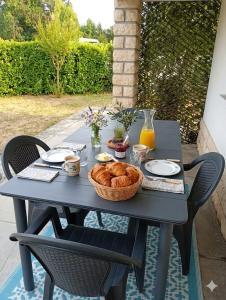 a picnic table with a basket of bread and orange juice at Mady in Villeneuve-sur-Lot