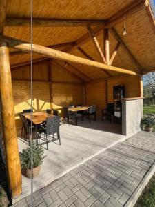 a pavilion with tables and chairs and a wooden roof at Roua Chalet in Nemţişor