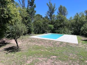 a swimming pool in the middle of a yard with trees at Cabañas Nido Escondido in Villa Ciudad Parque