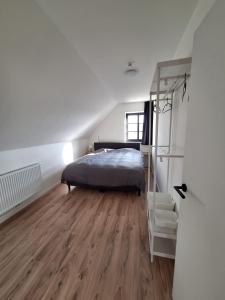 a bedroom with a bed and a ladder and a chair at 't Ooievaarszicht in Veurne