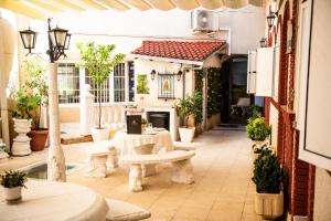 an outdoor patio with a white table and bench at Hostal La Corte in Carrión de los Condes