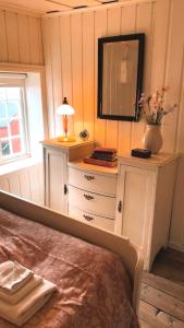 a bedroom with a dresser and a mirror at Pålberget in Råkvåg +25 photos