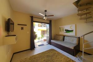 a living room with a door leading to a patio at Villa Garoupeta in Bombinhas