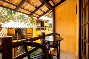 a patio with a table and chairs on a balcony at Villa Garoupeta in Bombinhas