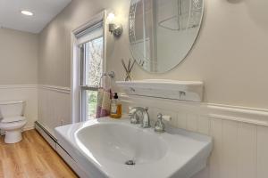 a white bathroom with a sink and a mirror at Tranquil Catskills Home w/ Creek & Fire Pits in Parksville +20 photos