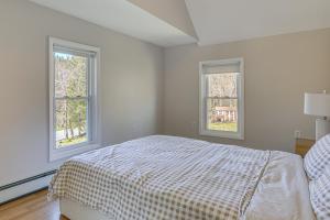 a white bedroom with a bed and two windows at Tranquil Catskills Home w/ Creek & Fire Pits in Parksville