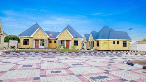a row of houses with yellow and blue roofs at Cozycore Apartment in Dodoma