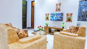 a living room with two chairs and a table at Cozycore Apartment in Dodoma
