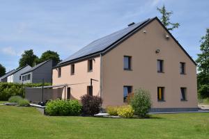 a large white house with a black roof at Chez Martine et Jean-Marc in Tintigny