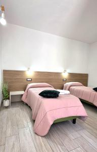 two beds in a room with pink sheets at Sienda Cesira in Muravera