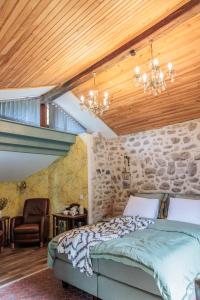 a bedroom with a bed and a stone wall at Domaine Le Verger Kleinschalige B&B met groot zwembad en buitenkeuken in Saint-Estèphe +60 photos