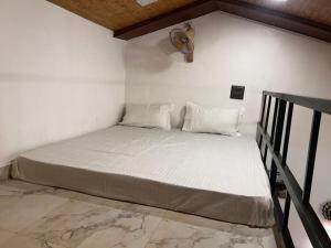 a bed with white sheets and pillows in a room at Velkar Cottage Mahabaleshwar in Mahabaleshwar