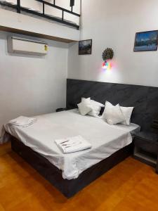 a bedroom with a large bed with white sheets and pillows at Velkar Cottage Mahabaleshwar in Mahabaleshwar +3 photos
