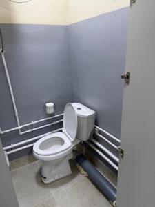 a bathroom with a white toilet in a stall at Bayan hostel in Osh