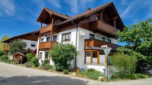 a large house with a wooden roof at Appartementhaus Elisabeth Winklhofer in Bad Füssing