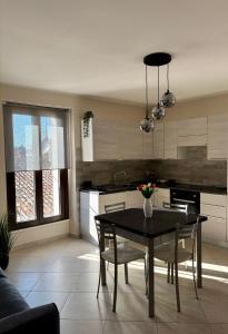 a kitchen with a black table and chairs in a room at Sirè House in LʼAquila