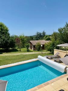 a swimming pool in the backyard of a house at Les Chalets du Brusquand in Marquay