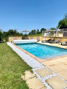 a swimming pool in a yard with aitating at Les Chalets du Brusquand in Marquay