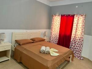 a bedroom with a bed with a red curtain at Ponta Preta Village 9 in Vila do Porto
