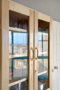 a wooden cabinet with two glass windows in a kitchen at Ponta Preta Village 9 in Vila do Porto +1 photo