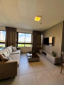 a living room with a couch and a tv at Heron Marinho Comfort Flat in Campina Grande