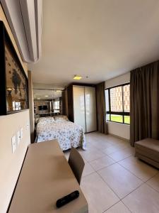 a room with a bed and a table in it at Heron Marinho Comfort Flat in Campina Grande