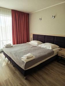 a bedroom with a large bed with two towels on it at Dominikana Apartament 41b in Sianozety +10 photos