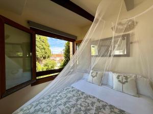 a bedroom with a bed with a mosquito net at Bungalow Aloha, Piscina Privada, Playa y Barbacoa in Benalmádena +42 photos