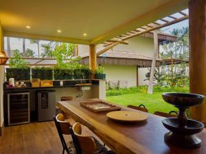 a kitchen with a wooden table with chairs and plants at Casa Baião in Fortim