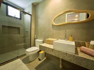 a bathroom with a toilet and a sink and a mirror at Casa Baião in Fortim +54 photos
