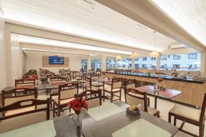 a restaurant with tables and chairs and a bar at Nobile Hotel Belém in Belém