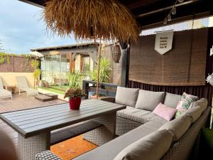 a living room with a couch and a table on a patio at Bungalow Aloha, Piscina Privada, Playa y Barbacoa in Benalmádena