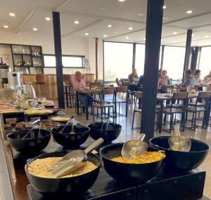 a buffet with bowls of food on a table in a restaurant at Geikie Lodge in Torres del Paine