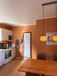 a kitchen with a table and a white refrigerator at Guesthouse Leon - Historic Home Near City Center with Free Parking in Tórshavn