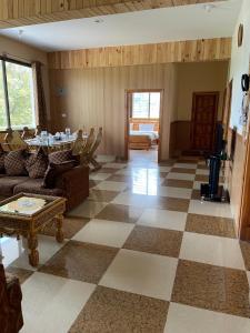 a living room with a checkered floor at Hillside Cottages, Kala Bagh in Nathia Gali