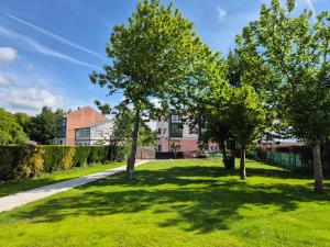 a park with trees in front of a building at Pensión Agro da Porta in Palas de Rei