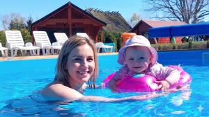 a woman and a baby in a swimming pool at Arcada in Jarosławiec