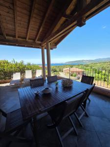 a wooden table and chairs on a patio with a view at Valinco Locations OLMETO PLAGE in Olmeto +43 photos