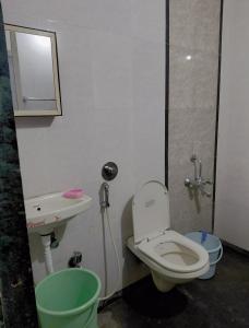 a bathroom with a toilet and a sink at Dikshit bungalow in Diveagar