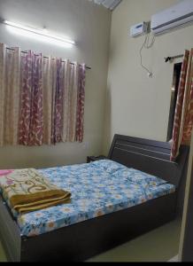 a small bedroom with a bed and a mirror at Dikshit bungalow in Diveagar