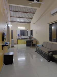 a large living room with a couch and a kitchen at Dikshit bungalow in Diveagar