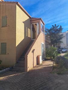a building with a staircase leading up to a door at Petit appartement bord de mer in Fleury