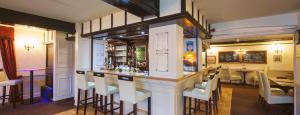 a bar in a restaurant with a table and chairs at Newtown House Hotel in South Hayling