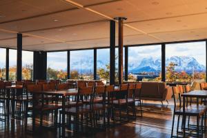 a restaurant with tables and chairs and mountains in the background at Geikie Lodge in Torres del Paine