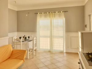 a living room with a table and a door to a kitchen at Ponta Preta Village 10 in Vila do Porto