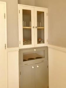 a white cabinet with glass doors in a room at Ponta Preta Village 10 in Vila do Porto