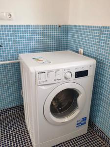 a washing machine in a bathroom with blue tiles at Ponta Preta Village 10 in Vila do Porto